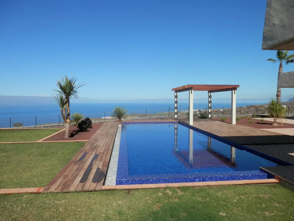 Villa swimming pool and lawn with a pergola and sea views in Tenerife